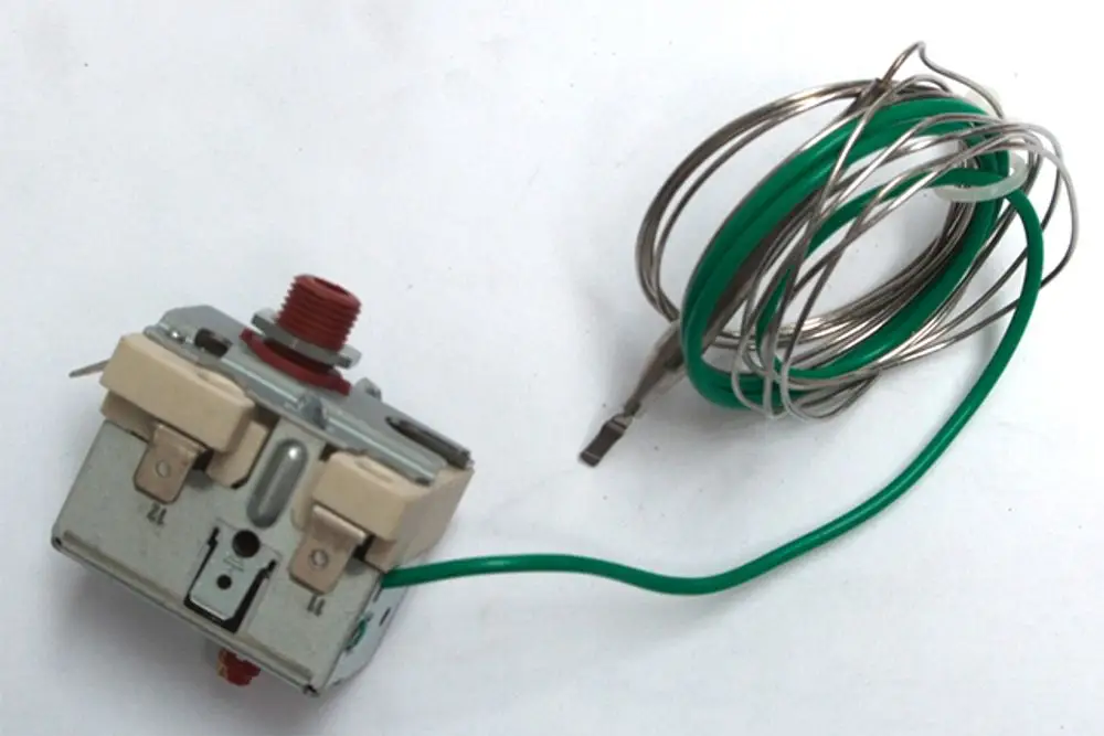 Schaltgerät von Daikin mit grünem Kabel und Verbindungselementen, geeignet für Heizsysteme. Das Gerät zeigt verschiedene Anschlussmöglichkeiten.